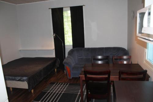 a living room with a table and a couch at Oulunsalo Apartment in Oulunsalo