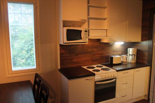 uma cozinha com um fogão e um micro-ondas em Oulunsalo Apartment em Oulunsalo