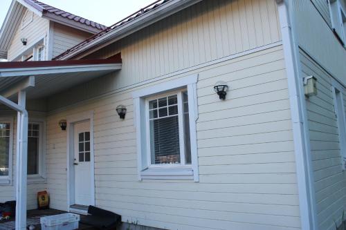 Una casa blanca con una ventana en el costado. en Oulunsalo Apartment en Oulunsalo