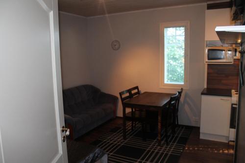 ein Wohnzimmer mit einem Tisch und einem Sofa in der Unterkunft Oulunsalo Apartment in Oulunsalo