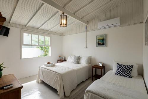 una camera da letto con due letti e una finestra di Ilhabela Studios a Ilhabela