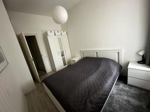 a bedroom with a black bed and two mirrors at Lovely apartment with parking on closed premises. in Pärnu