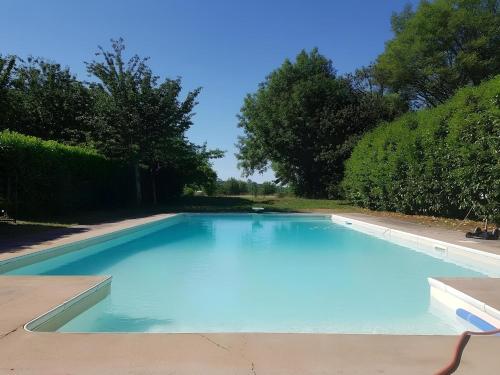 una grande piscina blu in un cortile di La Coudonie a Sarrazac