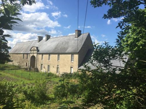 ein altes Backsteingebäude mit grauem Dach in der Unterkunft Gîte du Manoir in Subles