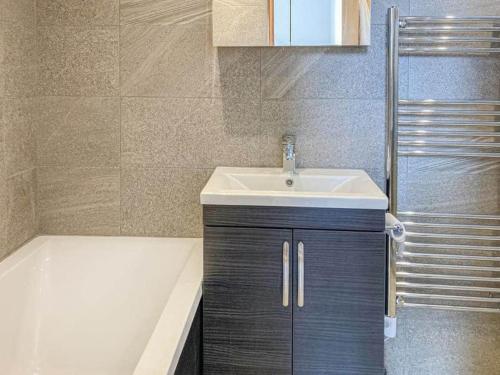 a bathroom with a sink and a bath tub at Remarkable 2-Bed Apartment near Bognor beaches in Bognor Regis