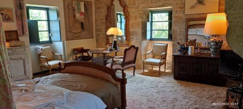 sypialnia z łóżkiem, stołem i krzesłami w obiekcie La Coudonie w mieście Sarrazac