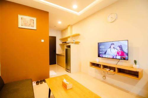 a living room with a flat screen tv on a wall at Formosa Spacious Apartments with Netflix & Pick Up Service by MESA in Nagoya