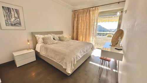 une chambre blanche avec un lit et une fenêtre dans l'établissement Sea view Marina Baie des Anges luxury apartment, à Villeneuve-Loubet