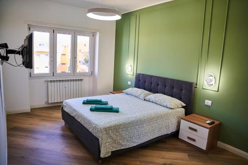 1 dormitorio con 1 cama con paredes verdes en Tramonto su Roma [ SELF CHECK-IN METRO A ] en Roma
