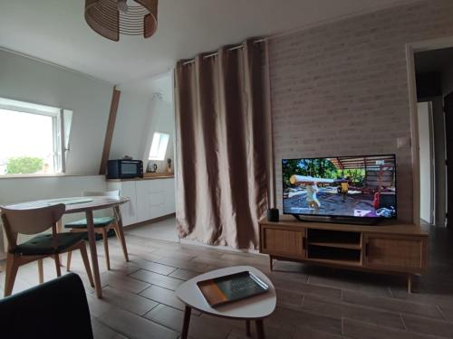 - un salon avec une télévision et une table à manger dans l'établissement Appartement T2 Centre Ville - 2/3 pers., à La Roche-Posay