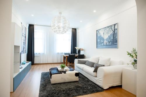 sala de estar con sofá blanco y lámpara de araña en ApartOpera, en Leópolis