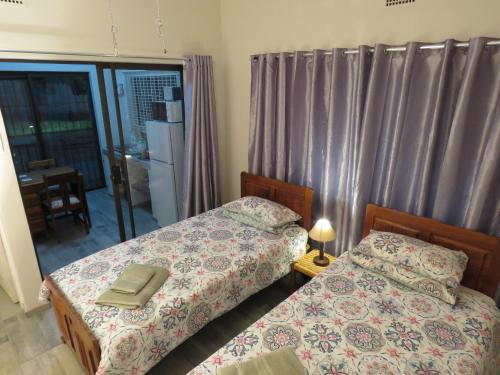 een slaapkamer met 2 bedden en een spiegel bij Parksig Self Catering in Musina