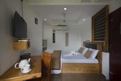 a bedroom with a white bed and a tv at Magni Home in Cochin