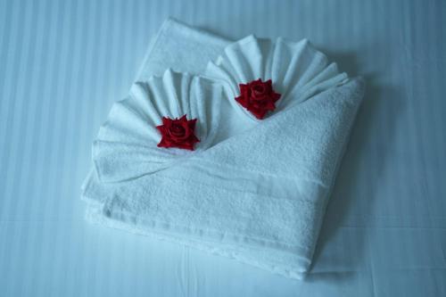 a white napkin with two red roses on it at Magni Home in Cochin