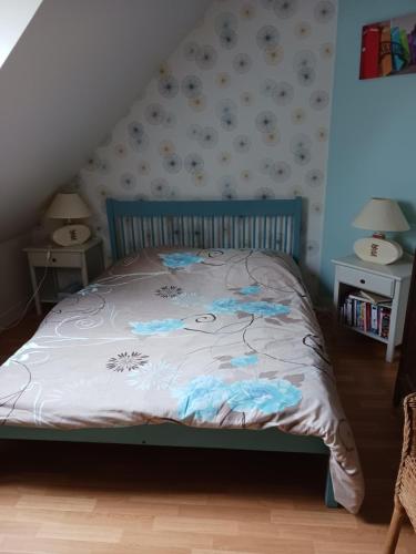 une chambre avec un lit avec une couette bleue et blanche dans l'établissement chambres chez l habitant, à Saint-Sauveur