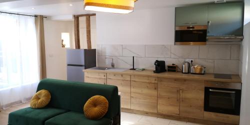 uma cozinha com um sofá verde num quarto em La promesse - T3 Hyper centre em Abbeville