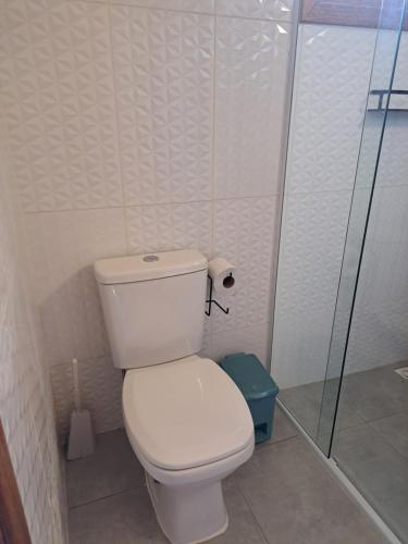 a bathroom with a toilet and a glass shower at Embahu Suítes - Vista para Pedra do Baú e banheira de imersão in Santo Antônio do Pinhal