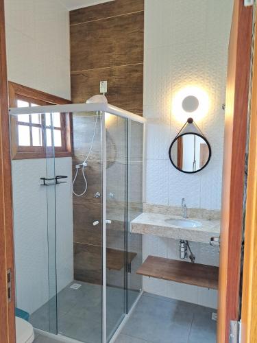 a bathroom with a glass shower and a sink at Embahu Suítes - Vista para Pedra do Baú e banheira de imersão in Santo Antônio do Pinhal