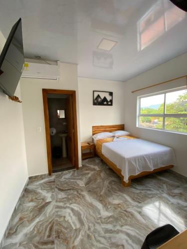 una camera con letto, TV e pavimento in marmo di Hotel EGIPTO a Apartadó