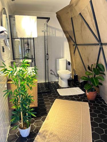 a bathroom with a toilet and plants in a tent at LAHZA SAPANCA in Sakarya