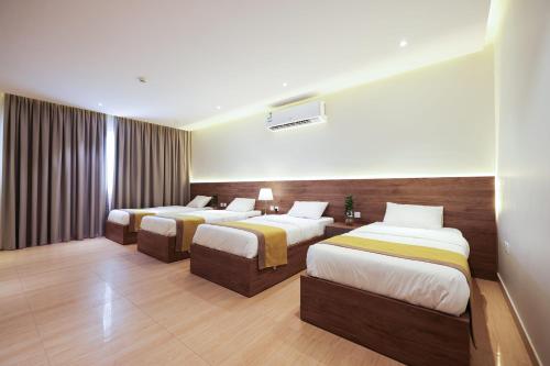 a hotel room with three beds in it at شقق المبات للشقق المخدومة in Riyadh