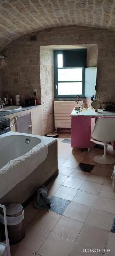 une grande salle de bain avec une baignoire et un lavabo dans l'établissement La Coudonie, à Sarrazac