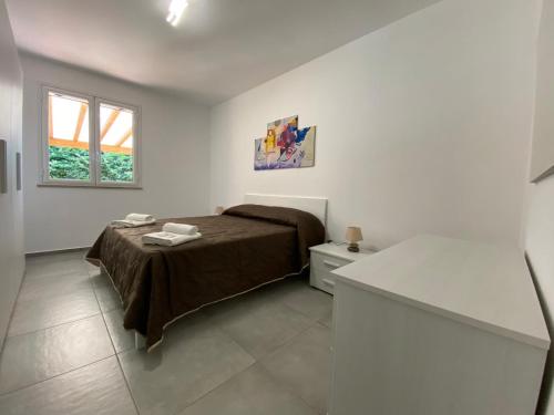 1 dormitorio con 1 cama en una habitación blanca en Residence le Coccinelle vicino a Cefalù, en Campofelice di Roccella