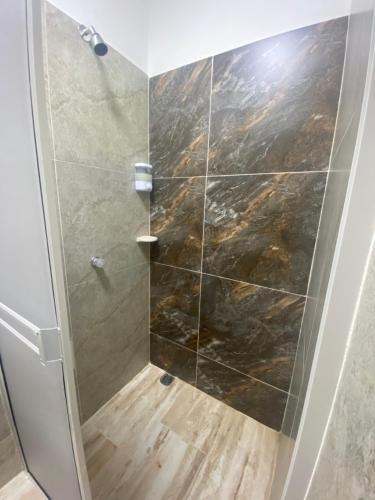 La salle de bains est pourvue d'une douche avec une porte en verre. dans l'établissement Hotel EGIPTO, à Apartadó