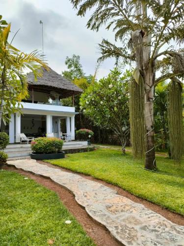 a house with a garden and a walkway at WHITE Nyumba Malindi in Malindi