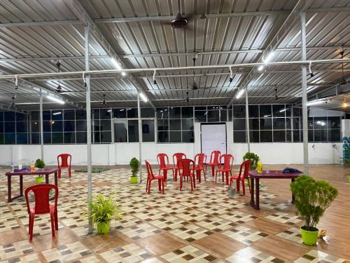 Cette chambre comprend des chaises et des tables rouges. dans l'établissement Sai Anjali Convention, à Konârak