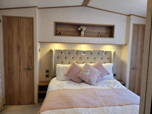 a bedroom with a large bed with pink pillows at New Forest 2-Bed Premium Holiday Home New Milton in New Milton