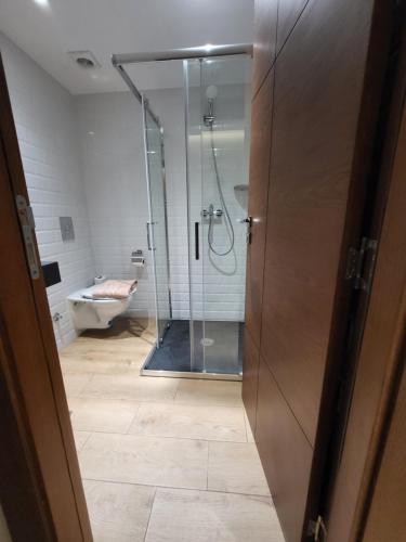 a bathroom with a shower and a toilet and a glass door at Hotel Appartement Tanger in Tangier