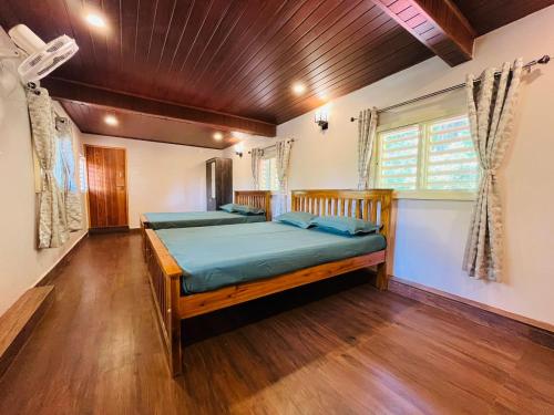 1 dormitorio con 2 camas y suelo de madera en GOKARNA JUNCTION - A vintage homestay, en Gokarna