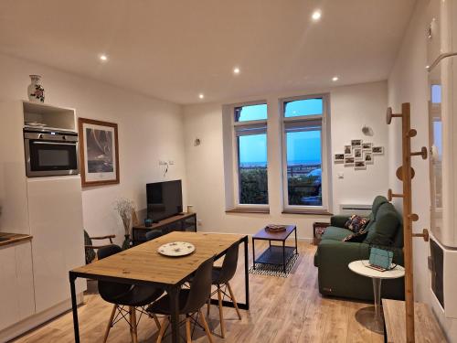 - un salon avec une table et un canapé vert dans l'établissement La perle de Houlgate, à Houlgate