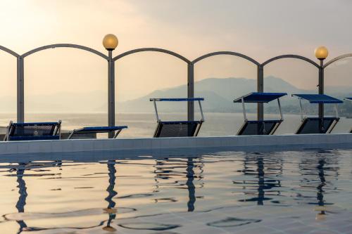 a pool with tables and chairs next to the water at Grande Albergo in Sestri Levante