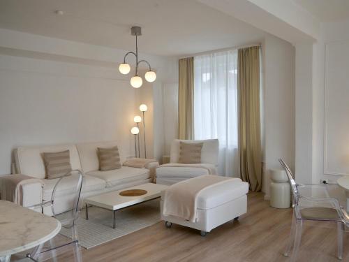 Sala de estar blanca con sofá y mesa en MOONROOMS Cityapartment 2 in Bad Bevensen, en Bad Bevensen
