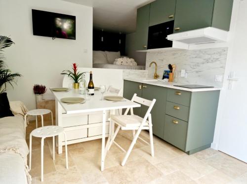 une cuisine avec une table et des chaises dans une pièce dans l'établissement Studio Au bas des crêtes en bas de villa à La Ciotat proche de la mer et de Marseille, à La Ciotat