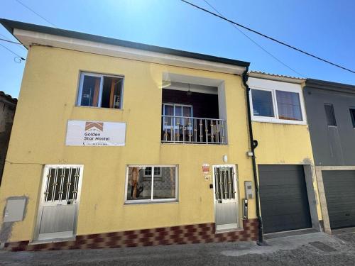 una casa gialla con due porte e una finestra di HOSTEL GOLDEN STAR a Gião