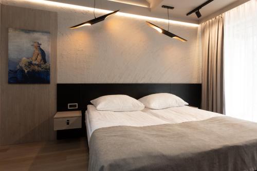 クリニツァ・モルスカにあるFour Windsのベッドルーム1室(ベッド1台付)が備わります。壁には絵画が飾られています。