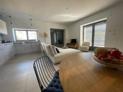 a large living room with a table and a kitchen at Beaujolais - Maison pierres dorées in Ville-sur-Jarnioux