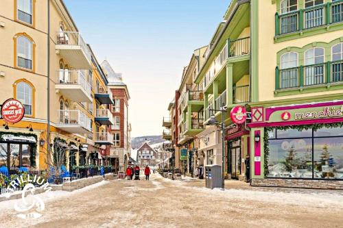 a city street with buildings and people walking down it at Blue Mountain, Collingwood - Loft Condo, sleeps 4 in Blue Mountains