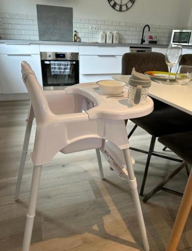 a white table and chair in a kitchen at L’Amistouso in Vedène
