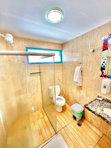 a bathroom with a shower and a toilet and a sink at Beira Mar Porto de Galinhas Hotel in Porto De Galinhas