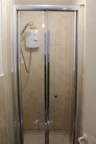 eine Dusche mit Glastür im Bad in der Unterkunft The Yellow House in London