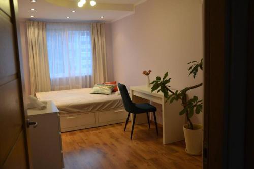 a bedroom with a bed and a desk and a chair at Apartment in Vilnius in Vilnius