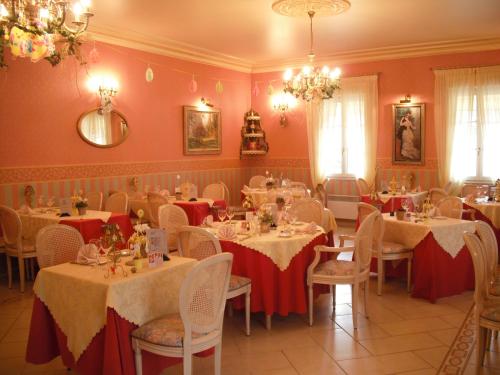 un comedor con mesas con manteles rojos y blancos en Hotel Le Clos du Montvinage en Étréaupont