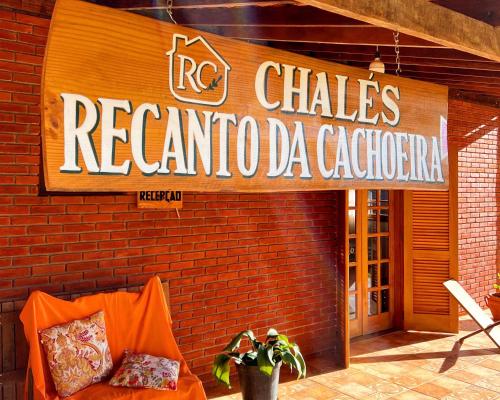 a sign on the side of a red brick building at Chalés Recanto da cachoeira in Monte Verde