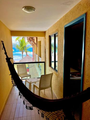 a hammock in a room with a view of the beach at Beira Mar Porto de Galinhas Hotel in Porto De Galinhas