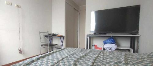 1 dormitorio con TV de pantalla plana y 1 cama en Edu 31, en Lima
