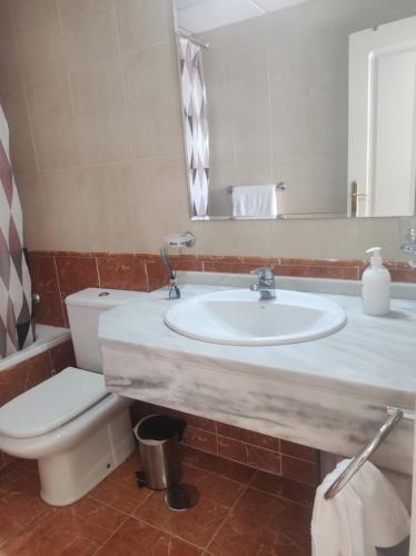 a bathroom with a sink and a toilet and a mirror at Ático con vistas al mar in Vícar